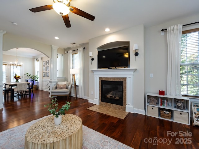 12928 Windy Lea Ln, Huntersville, NC 28078 - living area with ceiling fan, wood finished floors, arched walkways, a tile fireplace, and decorative columns