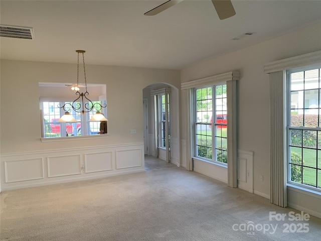 919 Lily Magnolia Ct, Fort Mill, SC 29707 - unfurnished dining area featuring arched walkways, ceiling fan, carpet floors, healthy amount of natural light, and wainscoting
