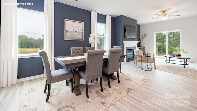 12020 Zazu Way, Charlotte, NC 28215 - dining area featuring wood finished floors, a glass covered fireplace, and ceiling fan