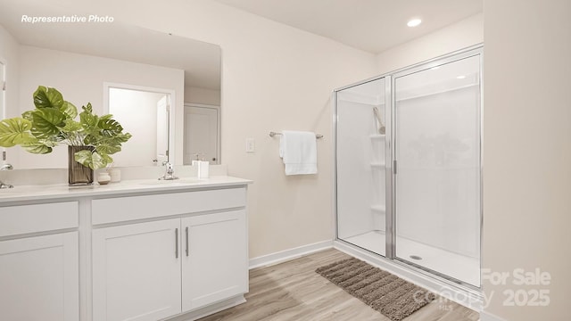 12019 Zazu Way, Charlotte, NC 28215 - bathroom with double vanity, a stall shower, wood finished floors, and recessed lighting