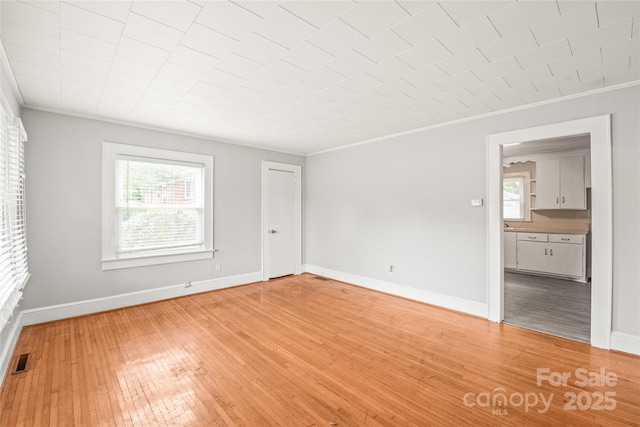 2722 Eastway Dr, Charlotte, NC 28205 - unfurnished room featuring crown molding, plenty of natural light, and light wood-style flooring