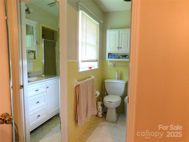 714 Shady Dr, Albemarle, NC 28001 - bathroom with tile walls, vanity, a shower with door, wainscoting, and tile patterned floors