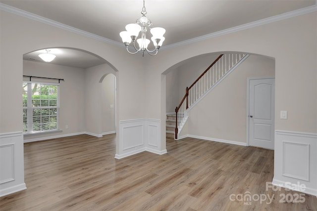 11538 Ardrey Crest Dr, Charlotte, NC 28277 - empty room with light wood-type flooring, arched walkways, a chandelier, ornamental molding, and a wainscoted wall