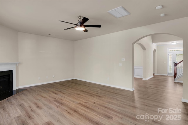 11538 Ardrey Crest Dr, Charlotte, NC 28277 - unfurnished living room with arched walkways, ceiling fan, wood finished floors, and a fireplace with raised hearth