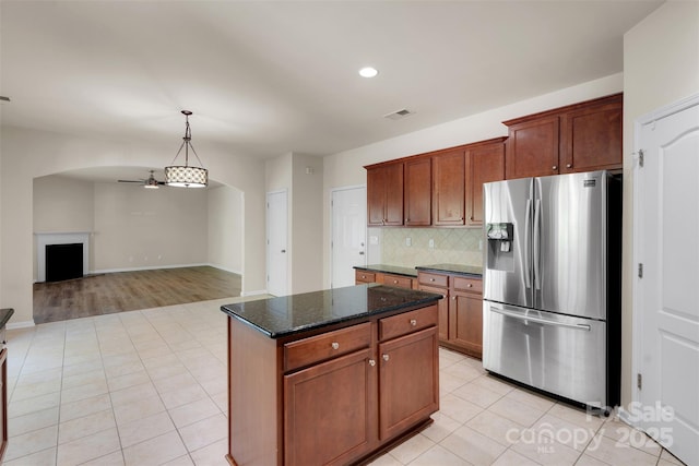 11538 Ardrey Crest Dr, Charlotte, NC 28277 - kitchen featuring stainless steel refrigerator with ice dispenser, ceiling fan, light tile patterned floors, dark stone countertops, and backsplash