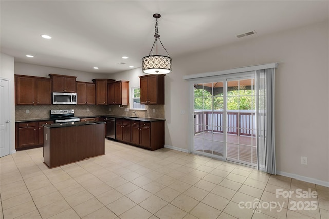 11538 Ardrey Crest Dr, Charlotte, NC 28277 - kitchen featuring appliances with stainless steel finishes, dark countertops, decorative backsplash, a kitchen island, and recessed lighting