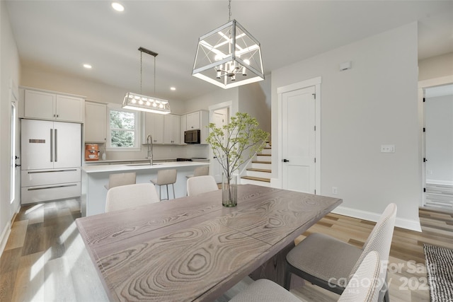 513 Sacco St, Belmont, NC 28012 - dining space featuring wood finished floors, a chandelier, stairs, and recessed lighting
