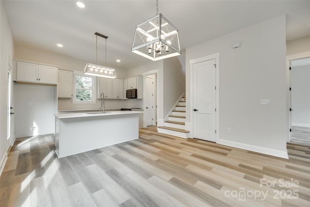 513 Sacco St, Belmont, NC 28012 - kitchen featuring light wood-style flooring, white cabinets, light countertops, recessed lighting, and a chandelier
