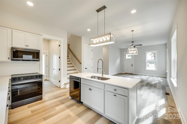 513 Sacco St, Belmont, NC 28012 - kitchen with appliances with stainless steel finishes, a ceiling fan, light wood finished floors, decorative light fixtures, and light countertops