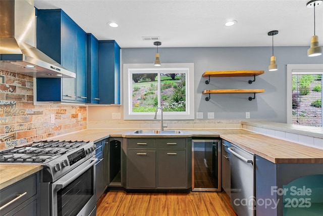 344 Hemlock Springs Trl, Weaverville, NC 28787 - kitchen featuring wall chimney range hood, appliances with stainless steel finishes, beverage cooler, butcher block counters, and light wood finished floors