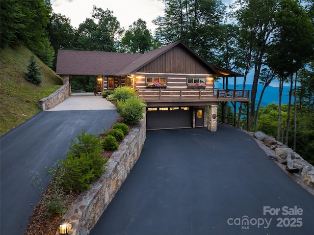 242 Anisidi Trl, Maggie Valley, NC 28751 - view of front facade with driveway, a garage, stone siding, board and batten siding, and a carport