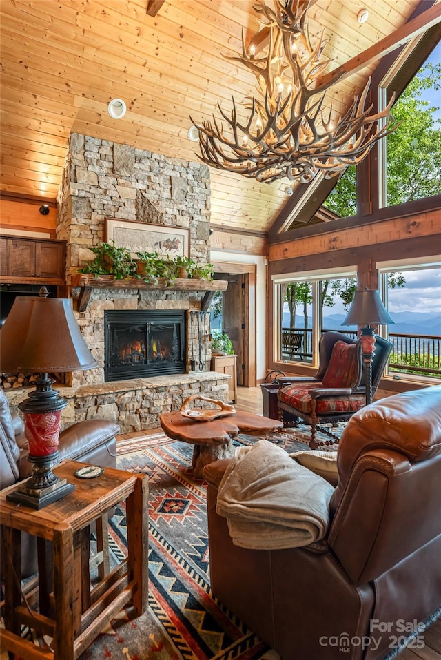 242 Anisidi Trl, Maggie Valley, NC 28751 - living room with wood ceiling, a chandelier, high vaulted ceiling, a stone fireplace, and wood walls