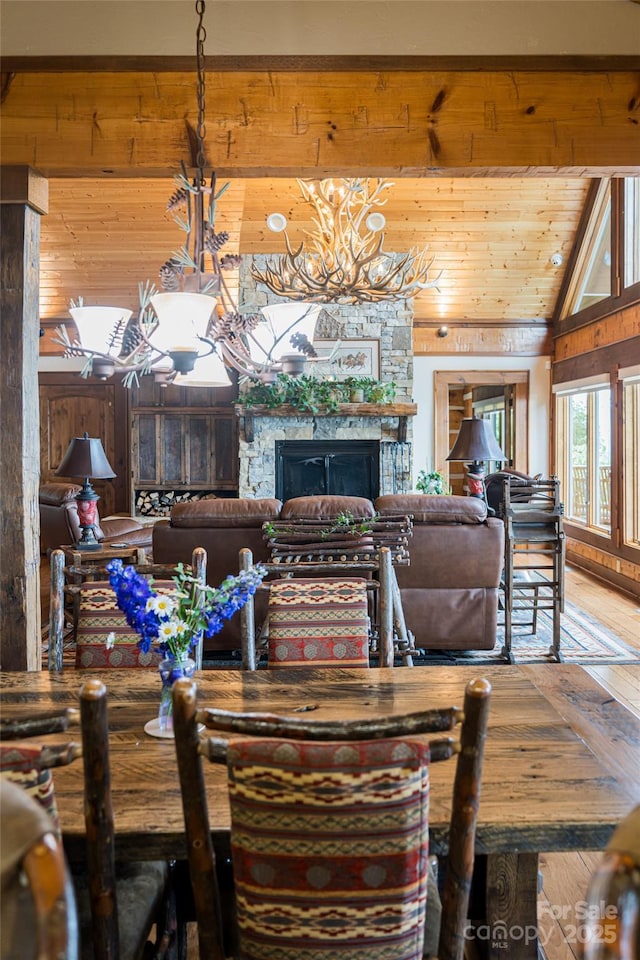 242 Anisidi Trl, Maggie Valley, NC 28751 - dining space featuring a stone fireplace, vaulted ceiling, wood walls, wood ceiling, and a chandelier