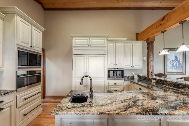 242 Anisidi Trl, Maggie Valley, NC 28751 - kitchen featuring built in microwave, stainless steel oven, wooden ceiling, dark stone countertops, and light wood finished floors