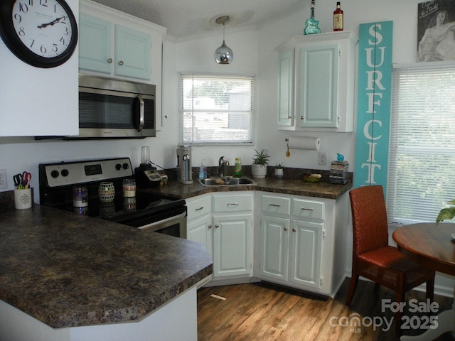166 Eagle Dr, New London, NC 28127 - kitchen featuring stainless steel appliances, dark countertops, wood finished floors, and white cabinets