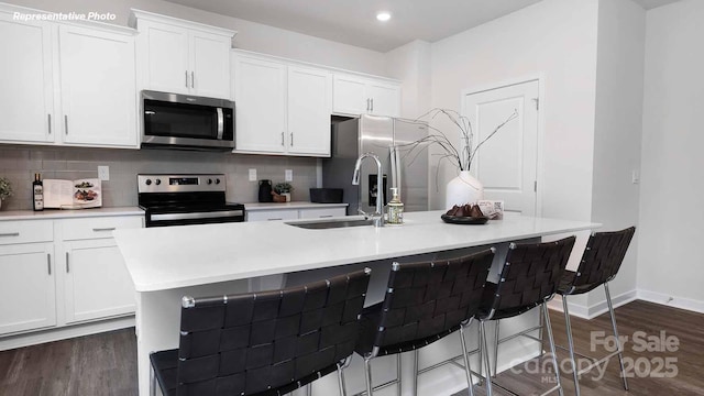 780 14th Avenue Ct NE, Hickory, NC 28601 - kitchen with appliances with stainless steel finishes, white cabinets, a center island with sink, dark wood-type flooring, and backsplash