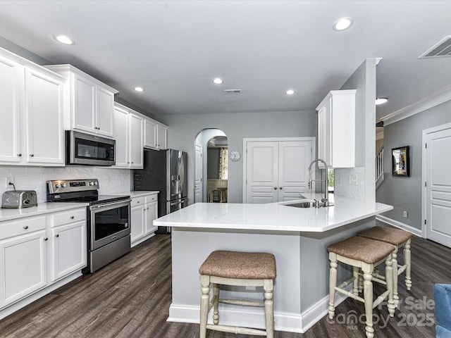 2003 Trigger Dr, Indian Trail, NC 28079 - kitchen with stainless steel appliances, arched walkways, a breakfast bar area, tasteful backsplash, and recessed lighting
