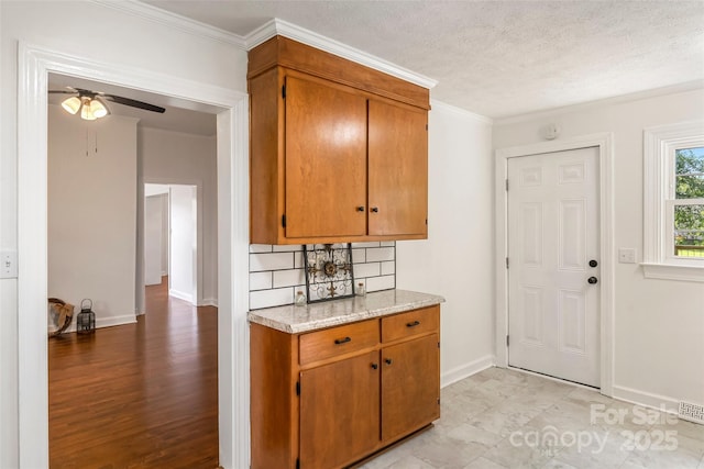 302 White St, Morganton, NC 28655 - kitchen with a ceiling fan, ornamental molding, brown cabinets, tasteful backsplash, and a textured ceiling