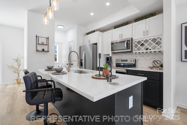 213 Knot St, Shelby, NC 28150 - kitchen with appliances with stainless steel finishes, light stone countertops, white cabinetry, backsplash, and light wood-style flooring