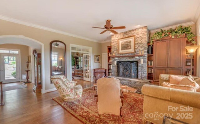 94 Spruce Hill Dr, Hendersonville, NC 28792 - living room with arched walkways, ceiling fan, a fireplace, wood finished floors, and crown molding