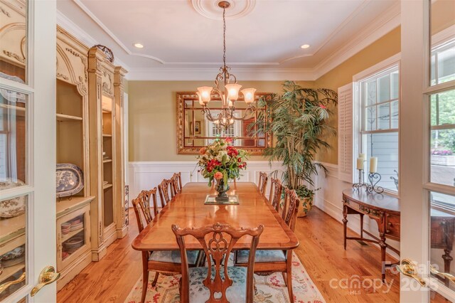 94 Spruce Hill Dr, Hendersonville, NC 28792 - dining space with a chandelier, wainscoting, ornamental molding, light wood-style floors, and a decorative wall