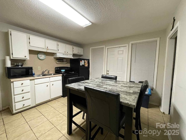 128 Pine St, Shelby, NC 28152 - kitchen featuring black appliances, a textured ceiling, light tile patterned flooring, white cabinets, and light countertops