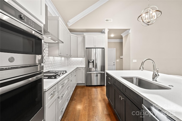 6107 Gold Springs Way, Denver, NC 28037 - kitchen featuring appliances with stainless steel finishes, ornamental molding, vaulted ceiling, white cabinets, and light countertops