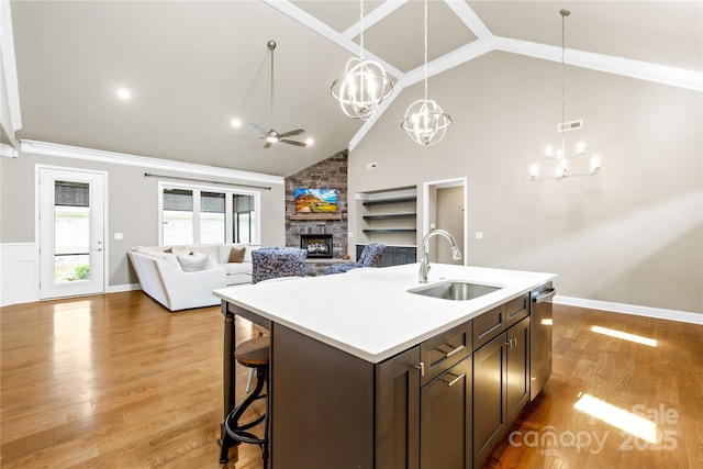 6107 Gold Springs Way, Denver, NC 28037 - kitchen featuring a fireplace, ceiling fan, a chandelier, dark brown cabinetry, and light wood-type flooring