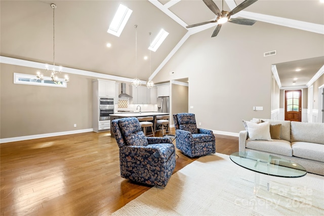 6107 Gold Springs Way, Denver, NC 28037 - living area featuring high vaulted ceiling, a chandelier, light wood-style floors, ceiling fan, and a skylight