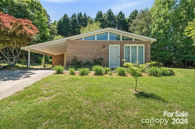 112 Lovelady Rd, Valdese, NC 28690 - mid-century inspired home featuring concrete driveway, brick siding, a front yard, and a carport