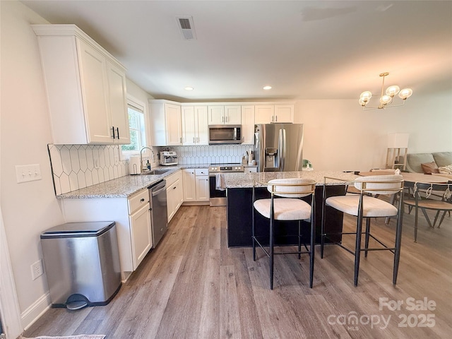 103 Springway Dr, Kannapolis, NC 28081 - kitchen featuring stainless steel appliances, light wood-type flooring, a kitchen bar, a center island, and recessed lighting