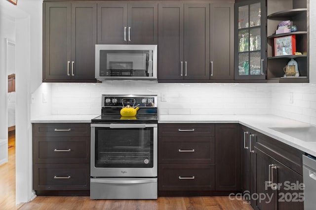 4 Sourwood Ln E, Asheville, NC 28805 - kitchen featuring stainless steel appliances, light countertops, tasteful backsplash, and glass insert cabinets
