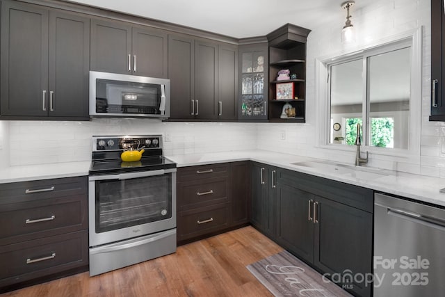 4 Sourwood Ln E, Asheville, NC 28805 - kitchen featuring appliances with stainless steel finishes, decorative backsplash, open shelves, and light wood-style floors