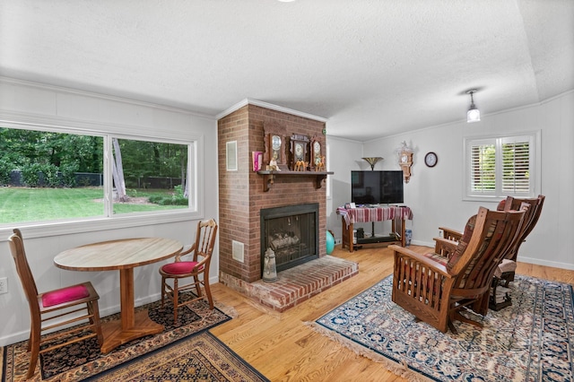 4 Sourwood Ln E, Asheville, NC 28805 - living area with a textured ceiling, wood finished floors, a fireplace, and crown molding