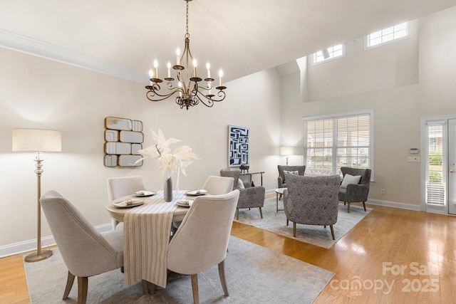 4442 Coventry Row Ct, Charlotte, NC 28270 - dining room featuring a chandelier, light wood-style flooring, and a towering ceiling