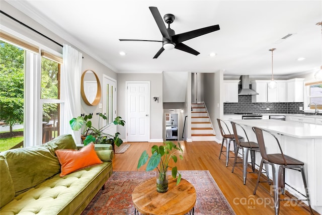 2919 Dunaire Dr, Charlotte, NC 28205 - living area featuring a ceiling fan, stairs, light wood-type flooring, crown molding, and recessed lighting