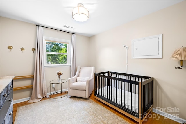 2919 Dunaire Dr, Charlotte, NC 28205 - bedroom with wood finished floors and a crib