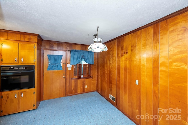 1216 Manchester Ln, Charlotte, NC 28227 - unfurnished dining area with carpet flooring, wood walls, a textured ceiling, and ornamental molding