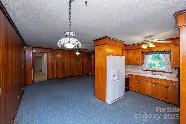 1216 Manchester Ln, Charlotte, NC 28227 - kitchen with white refrigerator with ice dispenser, a ceiling fan, dark carpet, light countertops, and brown cabinetry