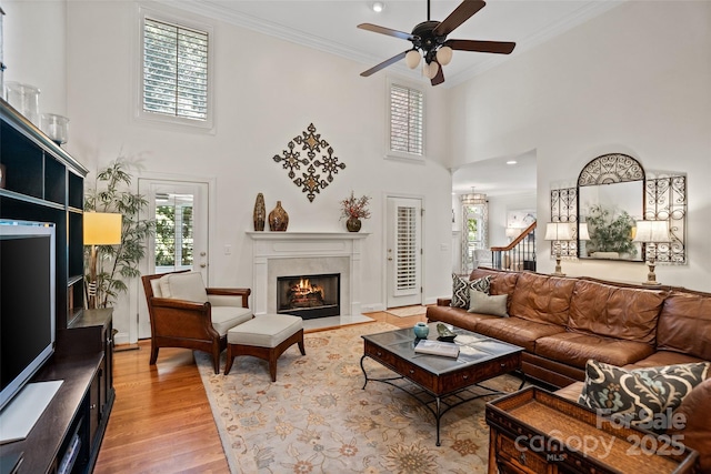 9027 Kirkley Ct, Charlotte, NC 28277 - living area featuring a ceiling fan, ornamental molding, a high ceiling, a fireplace with flush hearth, and light wood-style flooring