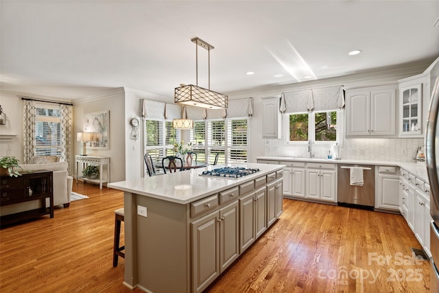9027 Kirkley Ct, Charlotte, NC 28277 - kitchen with appliances with stainless steel finishes, light wood-type flooring, backsplash, crown molding, and white cabinets