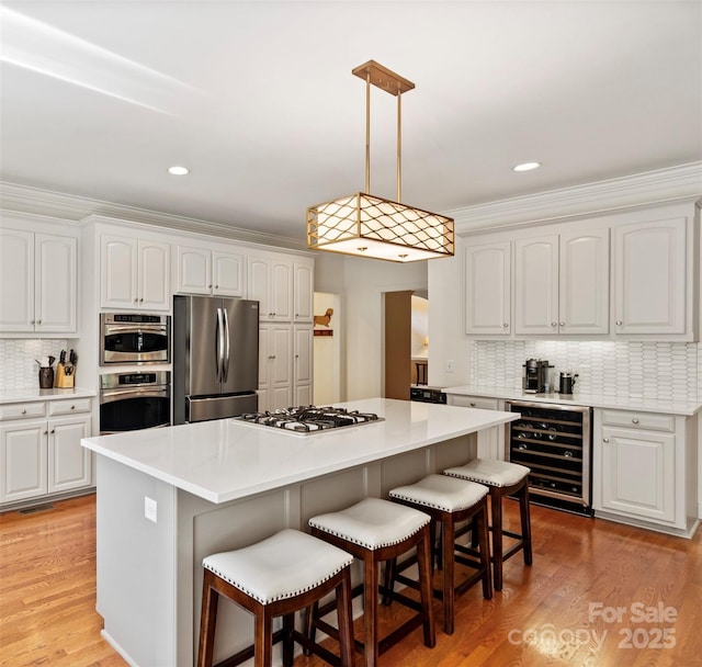 9027 Kirkley Ct, Charlotte, NC 28277 - kitchen with freestanding refrigerator, wine cooler, gas stovetop, a kitchen breakfast bar, and a center island