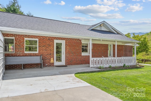 244 Carl Fox Rd, Burnsville, NC 28714 - view of front of house featuring a shingled roof, covered porch, brick siding, and a front lawn