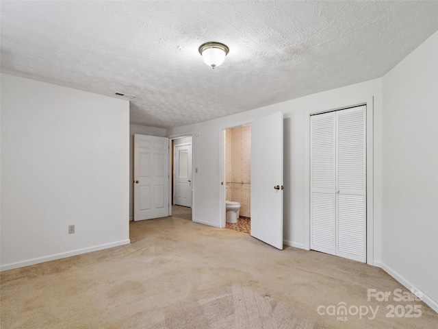 244 Carl Fox Rd, Burnsville, NC 28714 - unfurnished bedroom with carpet, a closet, ensuite bath, and a textured ceiling