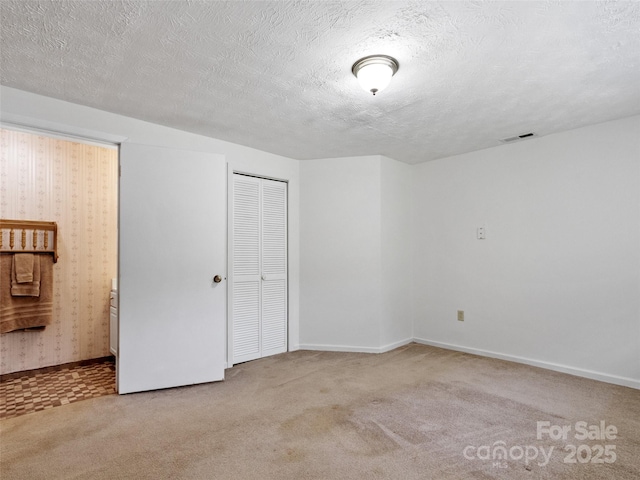 244 Carl Fox Rd, Burnsville, NC 28714 - unfurnished bedroom with carpet, a closet, a textured ceiling, and connected bathroom