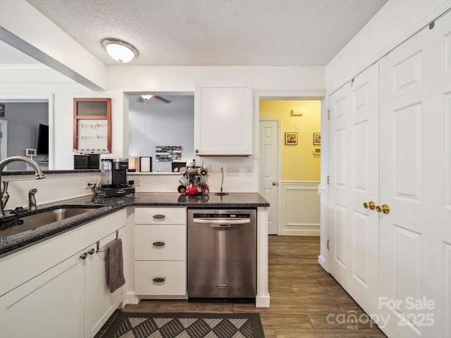 1252 Winding Path Rd, Lake Wylie, SC 29710 - kitchen with stainless steel dishwasher, white cabinetry, dark wood-style flooring, a wainscoted wall, and dark stone countertops