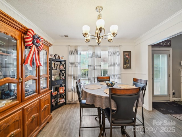 1252 Winding Path Rd, Lake Wylie, SC 29710 - dining room with a chandelier, light wood finished floors, crown molding, and a textured ceiling