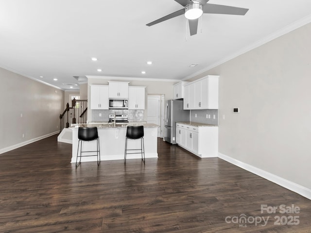 567 Big Sur Loop, Asheville, NC 28806 - kitchen with stainless steel appliances, crown molding, ceiling fan, decorative backsplash, and an island with sink