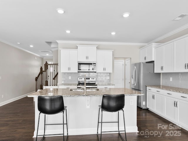 567 Big Sur Loop, Asheville, NC 28806 - kitchen featuring stainless steel appliances, ornamental molding, decorative backsplash, a breakfast bar area, and a center island with sink