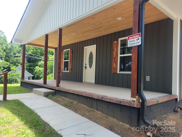 94 James St SW, Concord, NC 28025 - view of exterior entry featuring a porch and board and batten siding